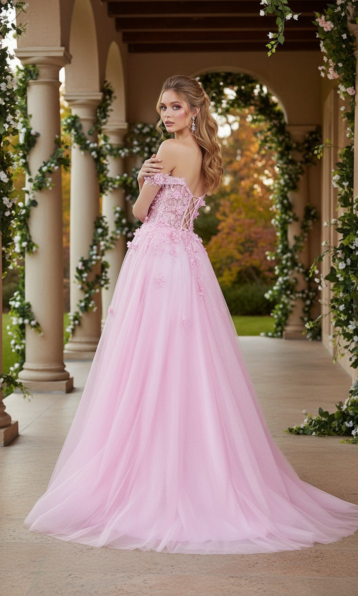 A woman wearing the Long Prom Dress: Cinderella Couture 8403J stands on a veranda with greenery and columns, looking over her shoulder at the camera.